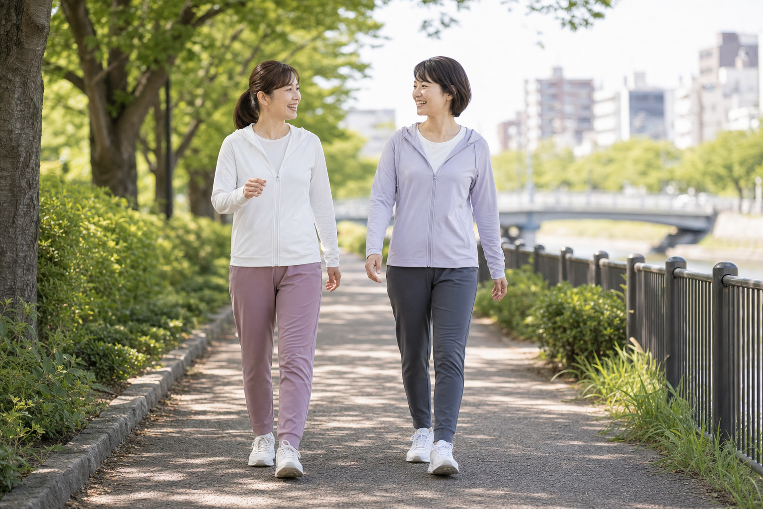 友人と会話しながらウォーキングを続ける日本人女性のイメージ