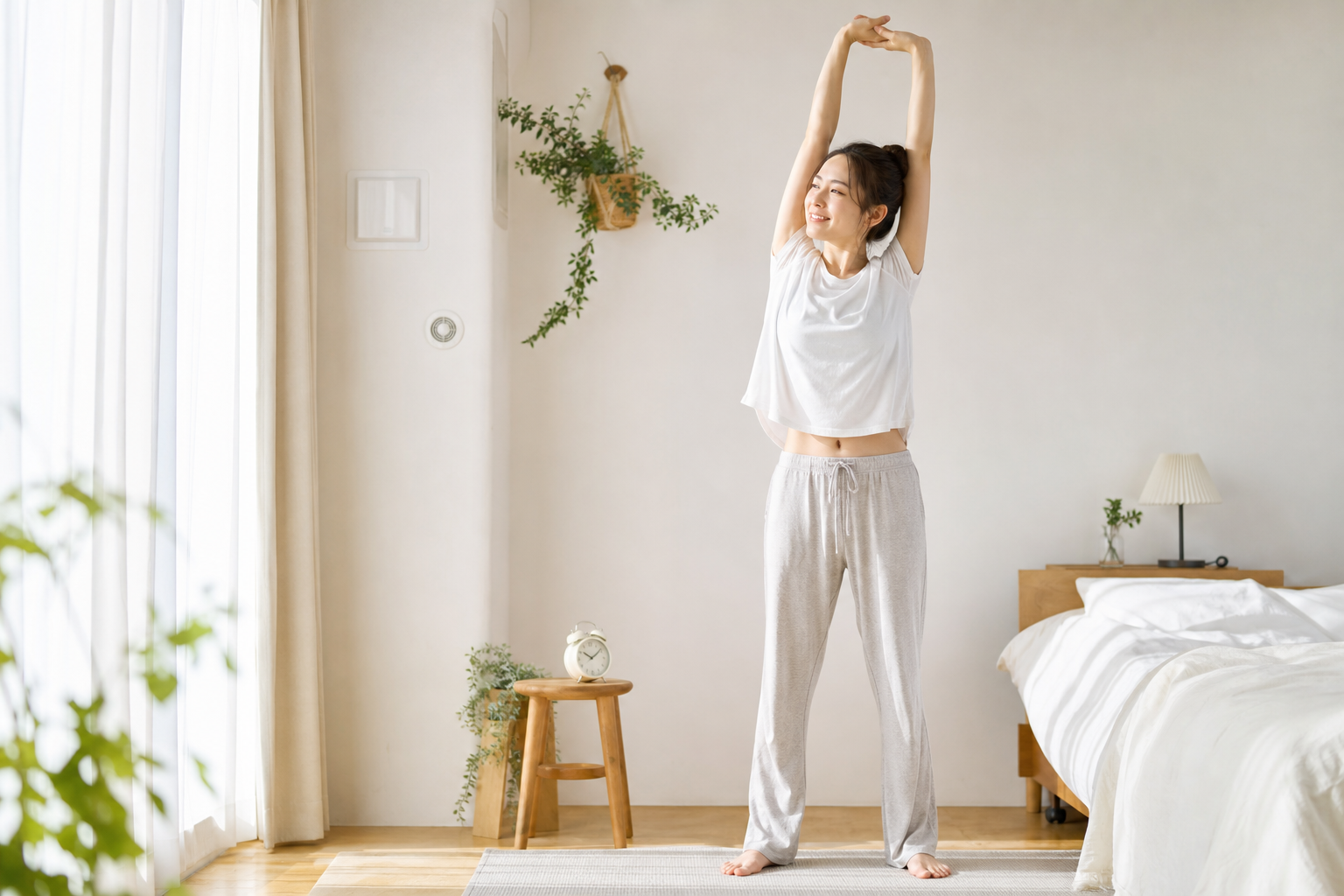 朝の部屋で全身を伸ばすストレッチルーティンを行う日本人女性のイメージ