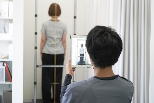 姿勢や可動域を確認して整体技法を選ぶ風景